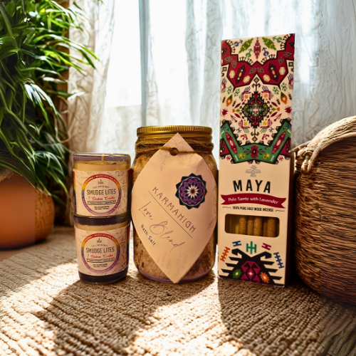 Candle, jar, and box labeled 'Maya' on a textured surface with plants in the background