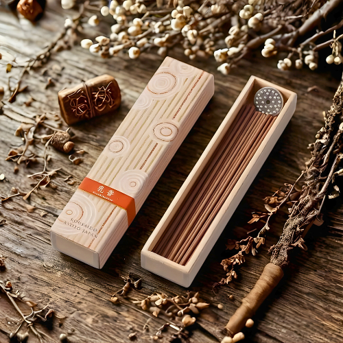 Wooden incense box with incense sticks on a wooden surface with dried plants.